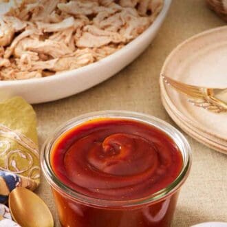 Pinterest graphic showing barbecue sauce in a small jar with meat and black pepper around it.