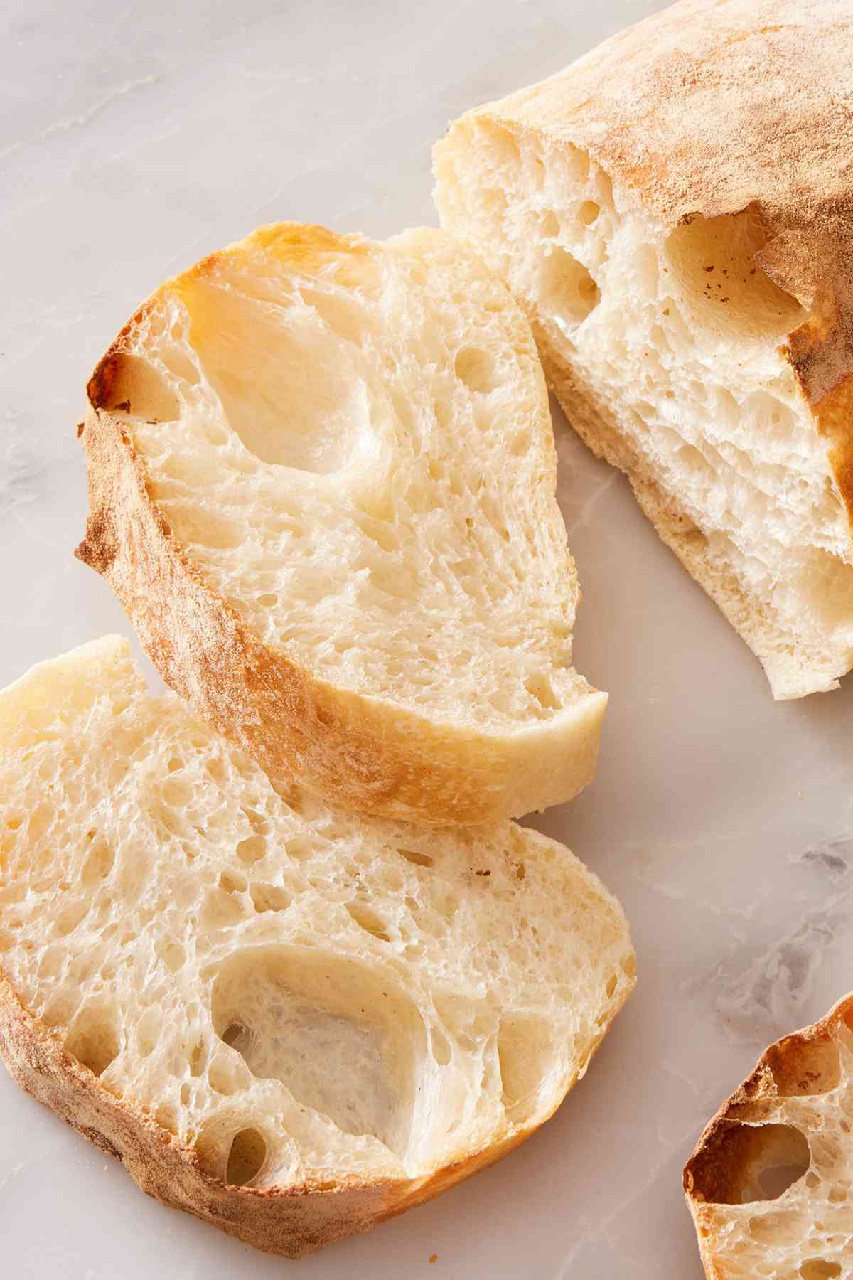 Close up of a sliced ciabatta loaf showcasing its airy interior.