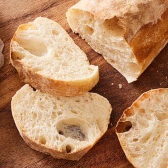 Close up of sliced ciabatta bread on a wooden board.