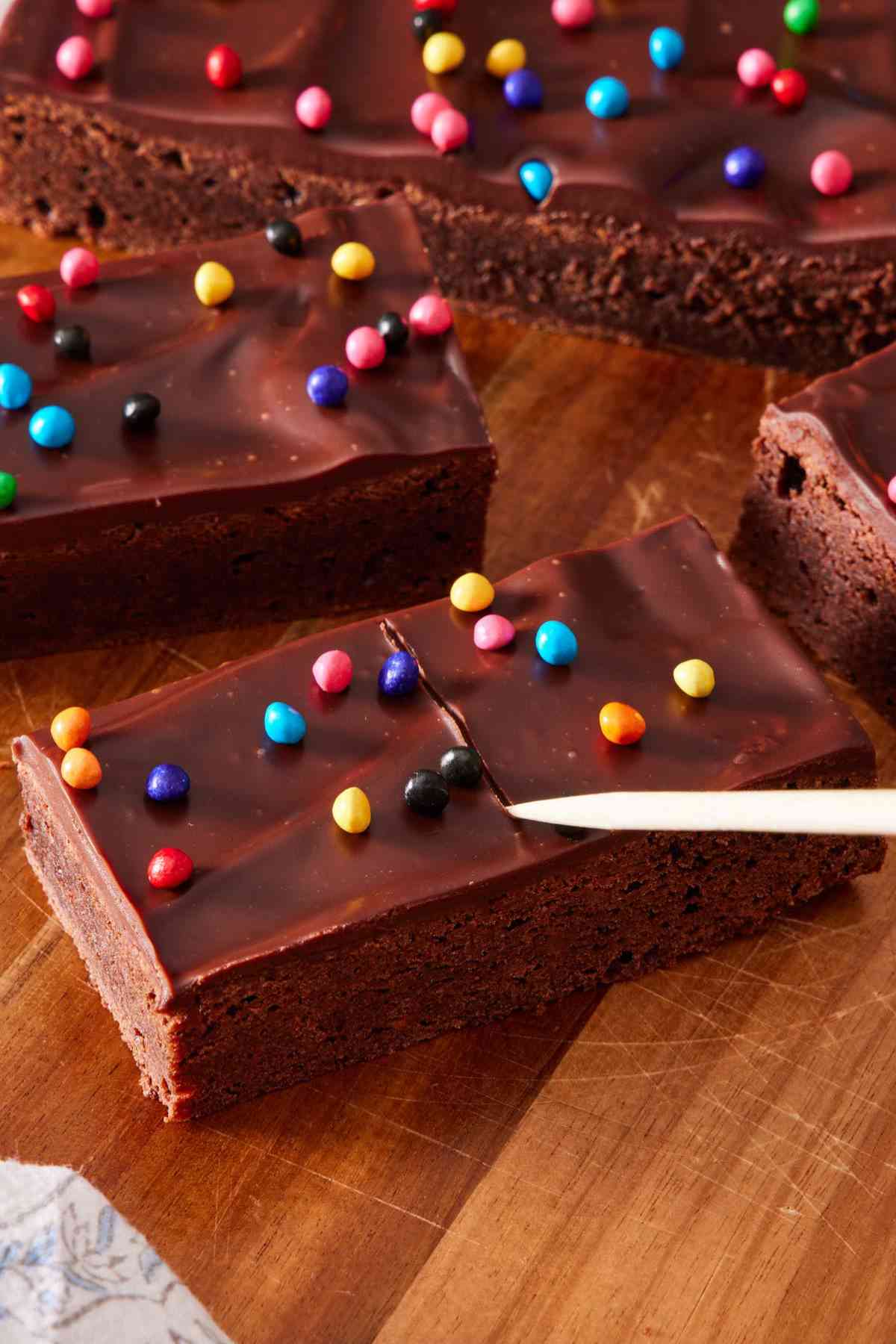 Drawing a line down the middle of cosmic brownie slabs with a skewer.