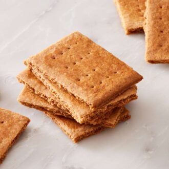 Close up of a stack of homemade graham crackers with more crackers around it.