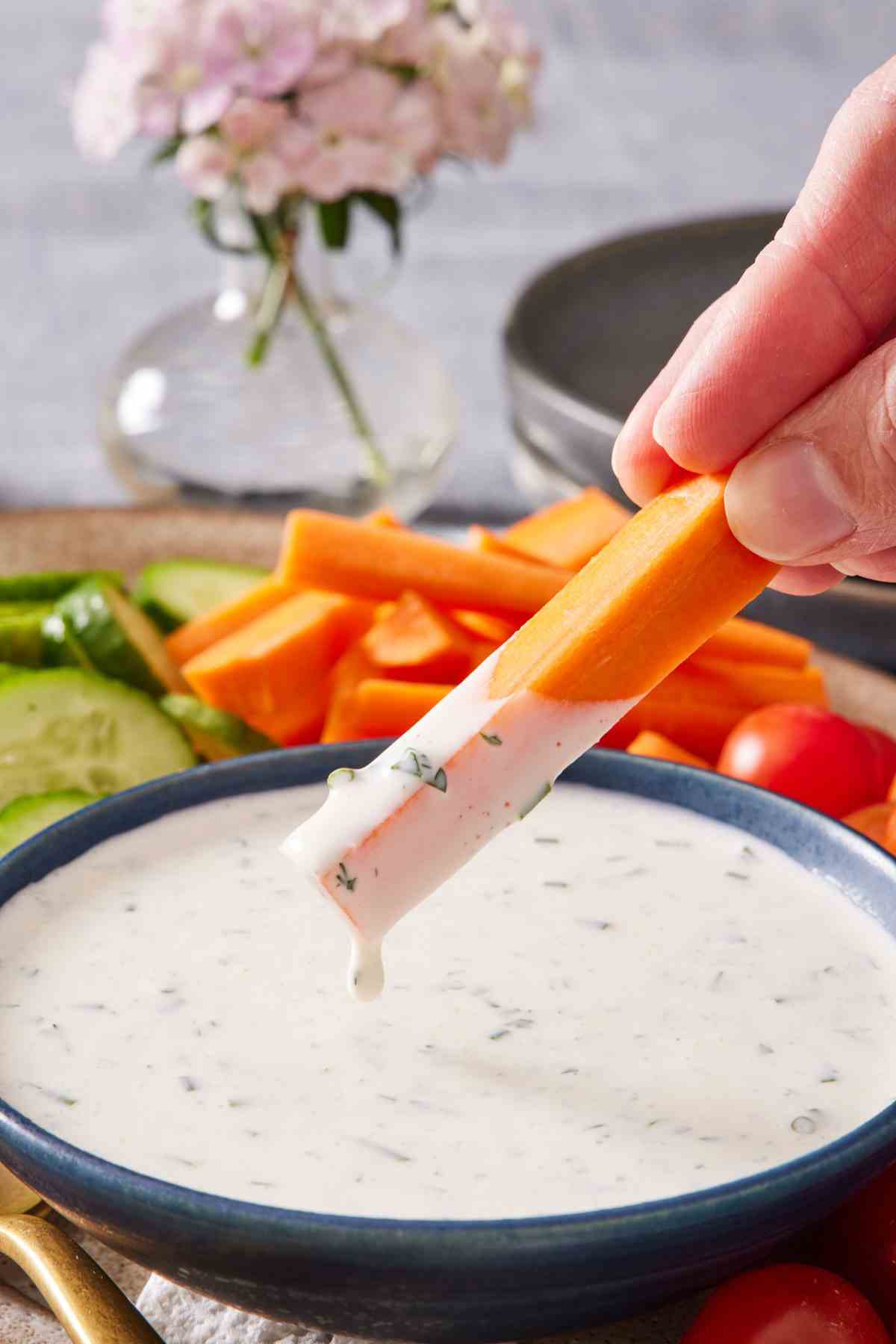 A carrot stick dipped into a bowl of homemade ranch dressing recipe.