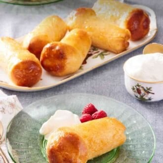 Pinterest graphic showing a baba au rhum on a small plate with berries and Chantilly cream, with more in the background on a platter.
