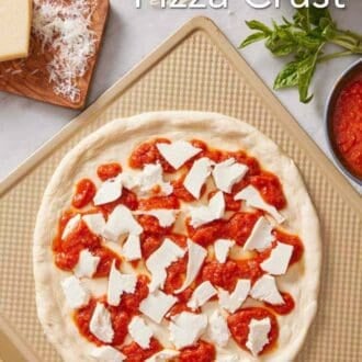 Pinterest graphic showing an unbaked sourdough pizza topped with pizza sauce and cheese.