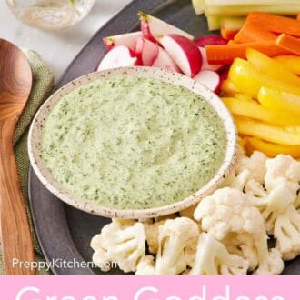 Pinterest graphic showing a small bowl of green goddess dressing on a platter with cut vegetables.