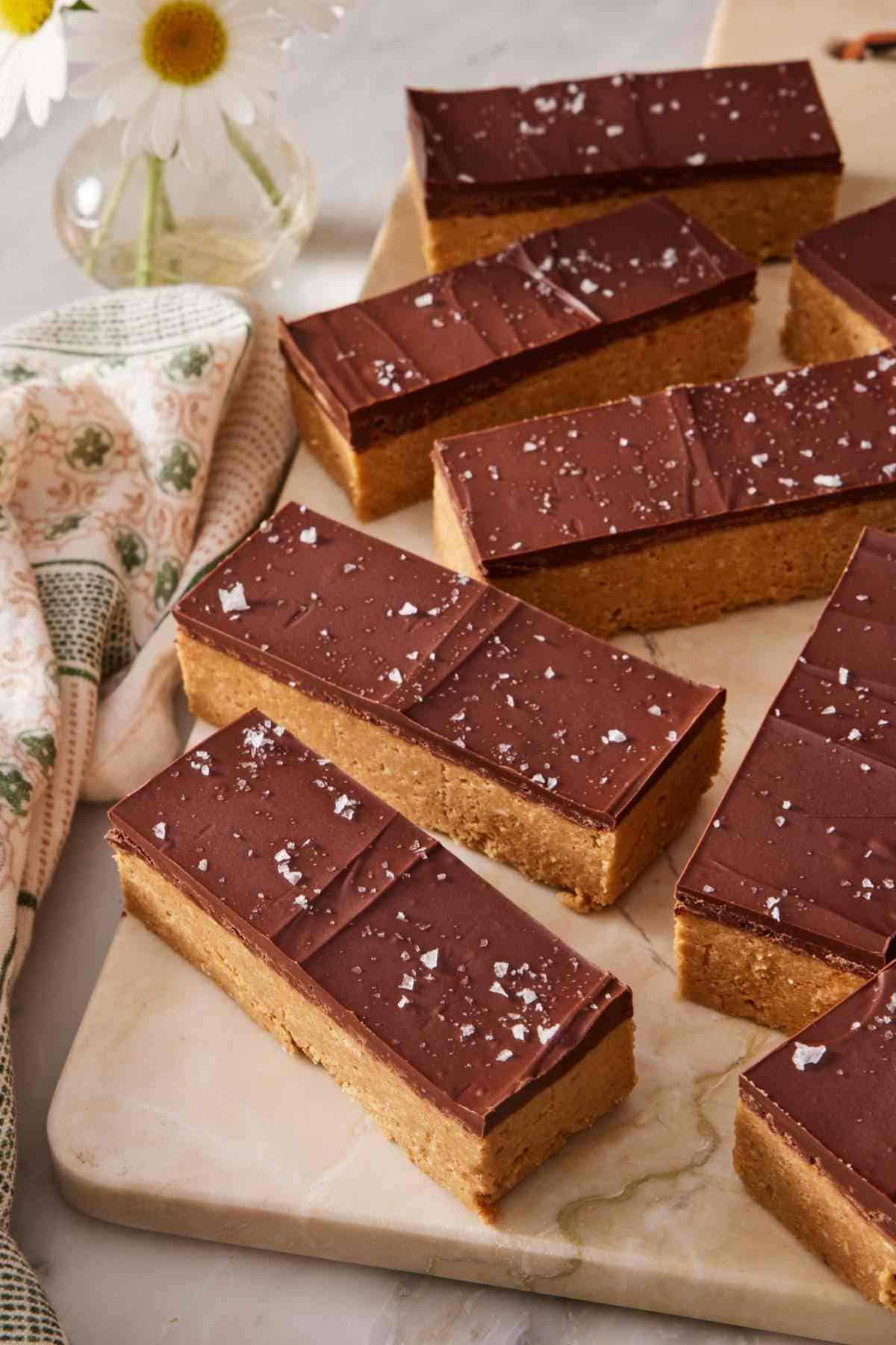 Peanut butter bars sprinkled with sea salt on a flat marble platter.