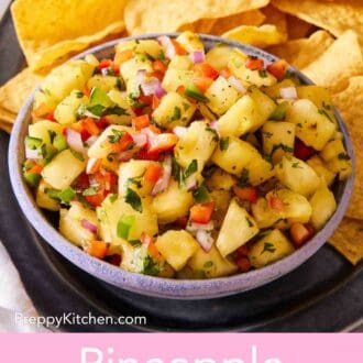 Pinterest graphic showing pineapple salsa in a bowl on a platter of chips.