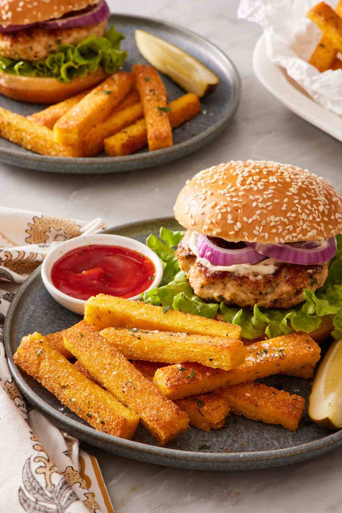 Polenta fries on a plate with a burger and ketchup.
