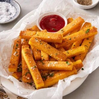 Polenta fries on a platter with ketchup.