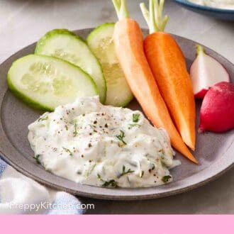 Pinterest graphic showing tzatziki on a plate with fresh veggies.