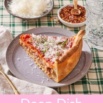 A slice of Chicago deep dish pizza on a small plate with small dishes of red pepper flakes and grated parmesan cheese in the background.