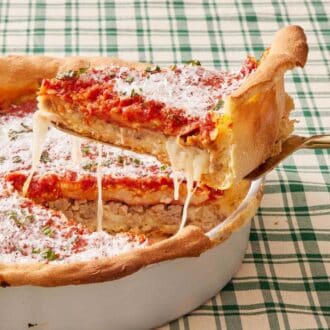 A slice of Chicago deep dish pizza lifted out of the baking dish.