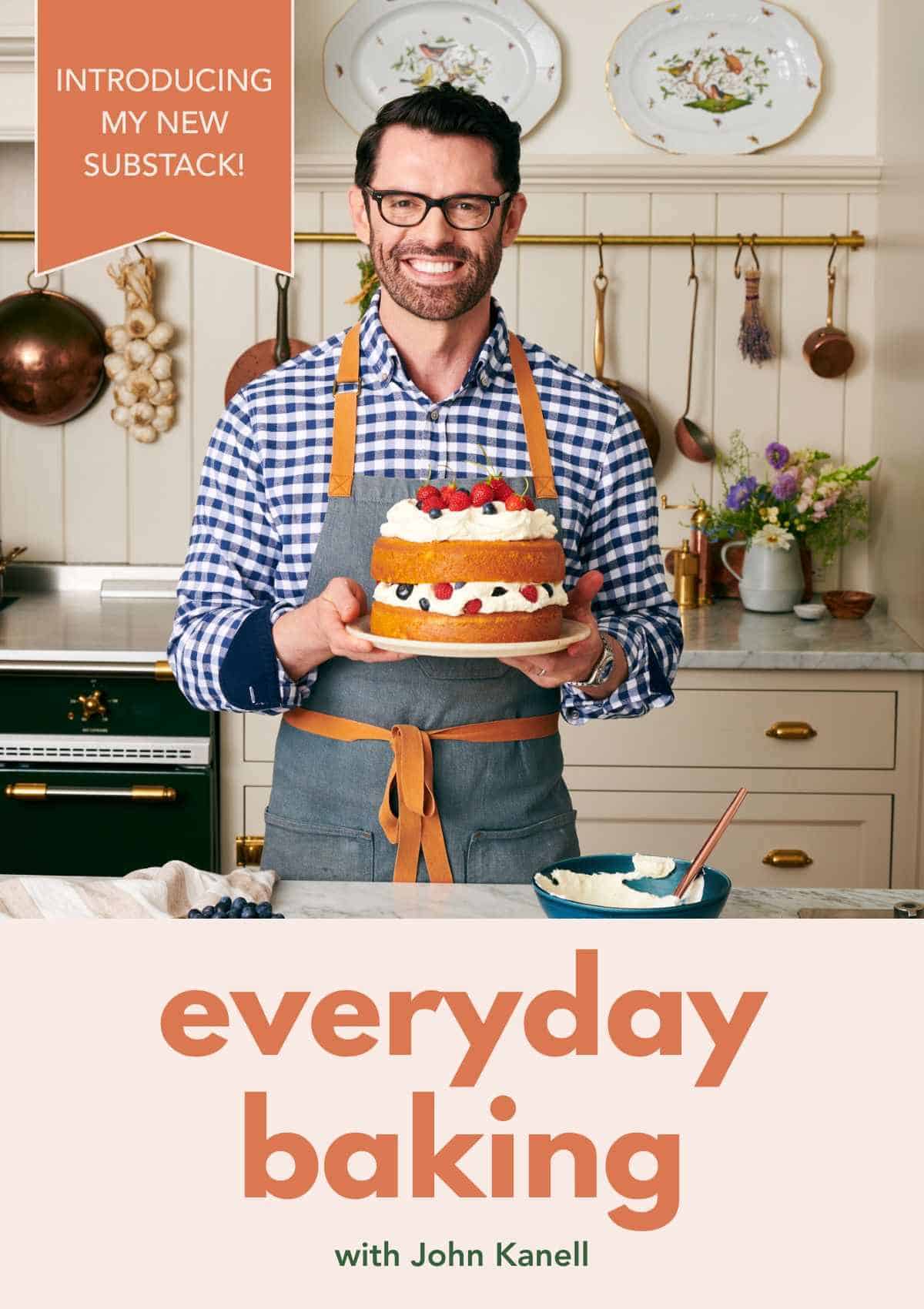 Image of John Kanell in his kitchen holding a cake on a cake plate to launch his new Substack.