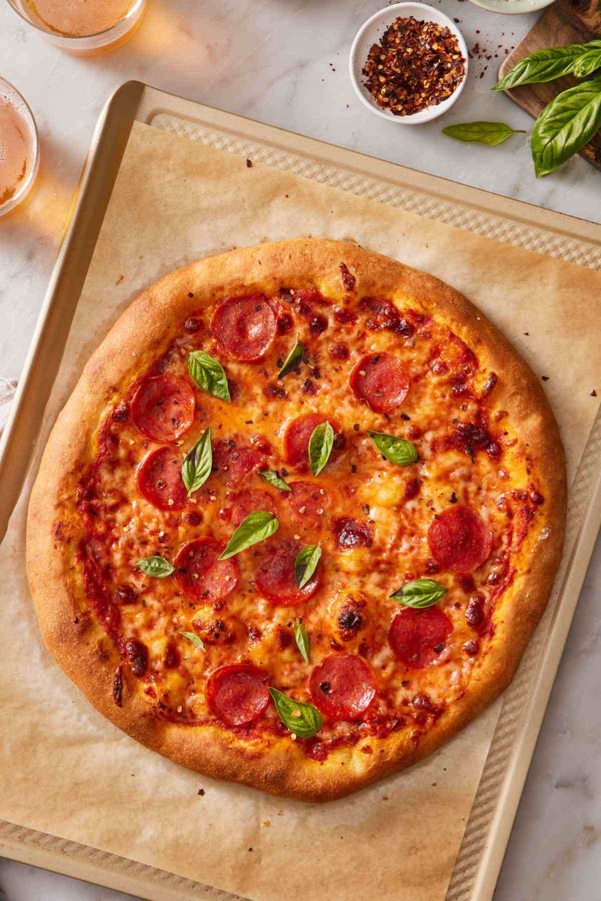 Overhead shot of pizza using homemade pizza dough with cheese, pepperoni, and basil.