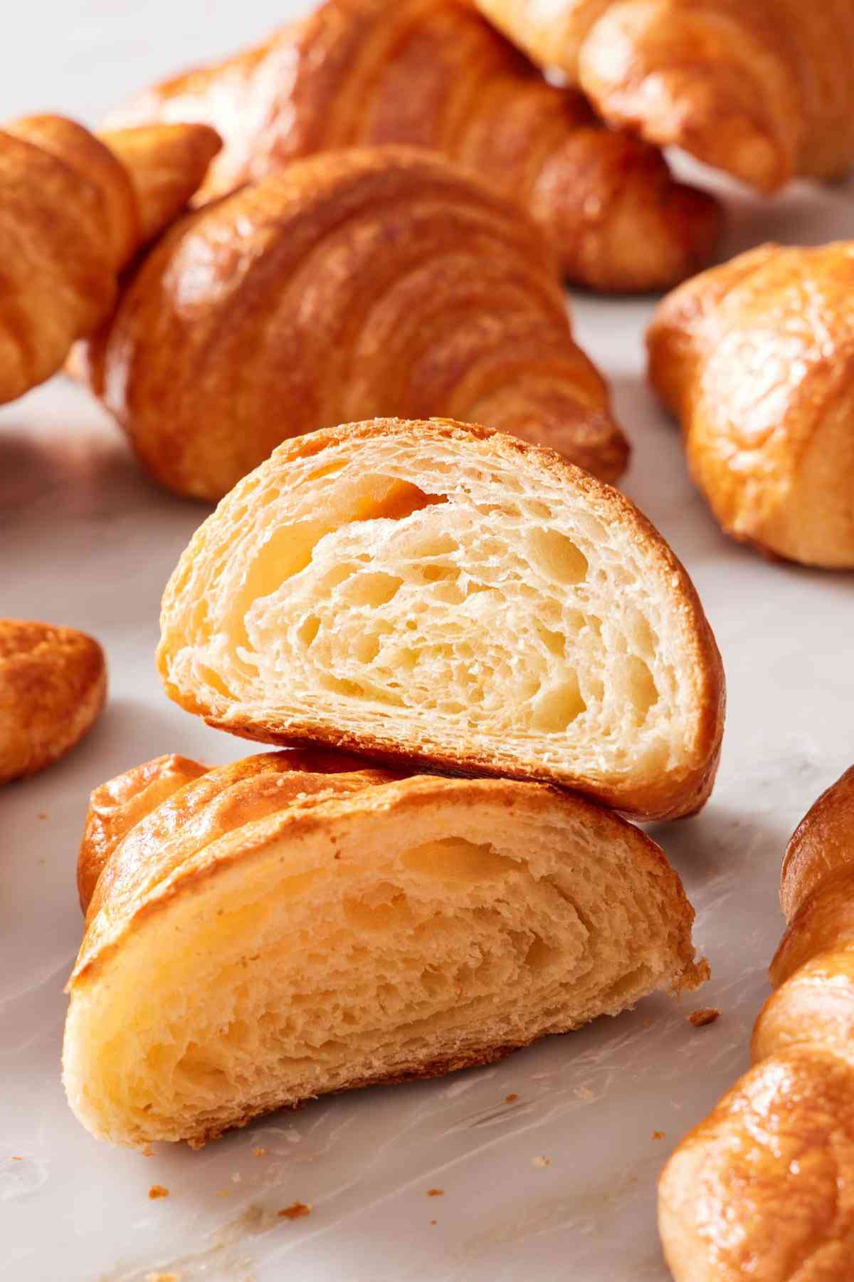 A croissant cut in half to show off its flaky layers.