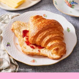Pinterest graphic showing a croissant served with butter and jam, with a cup of coffee on the side.