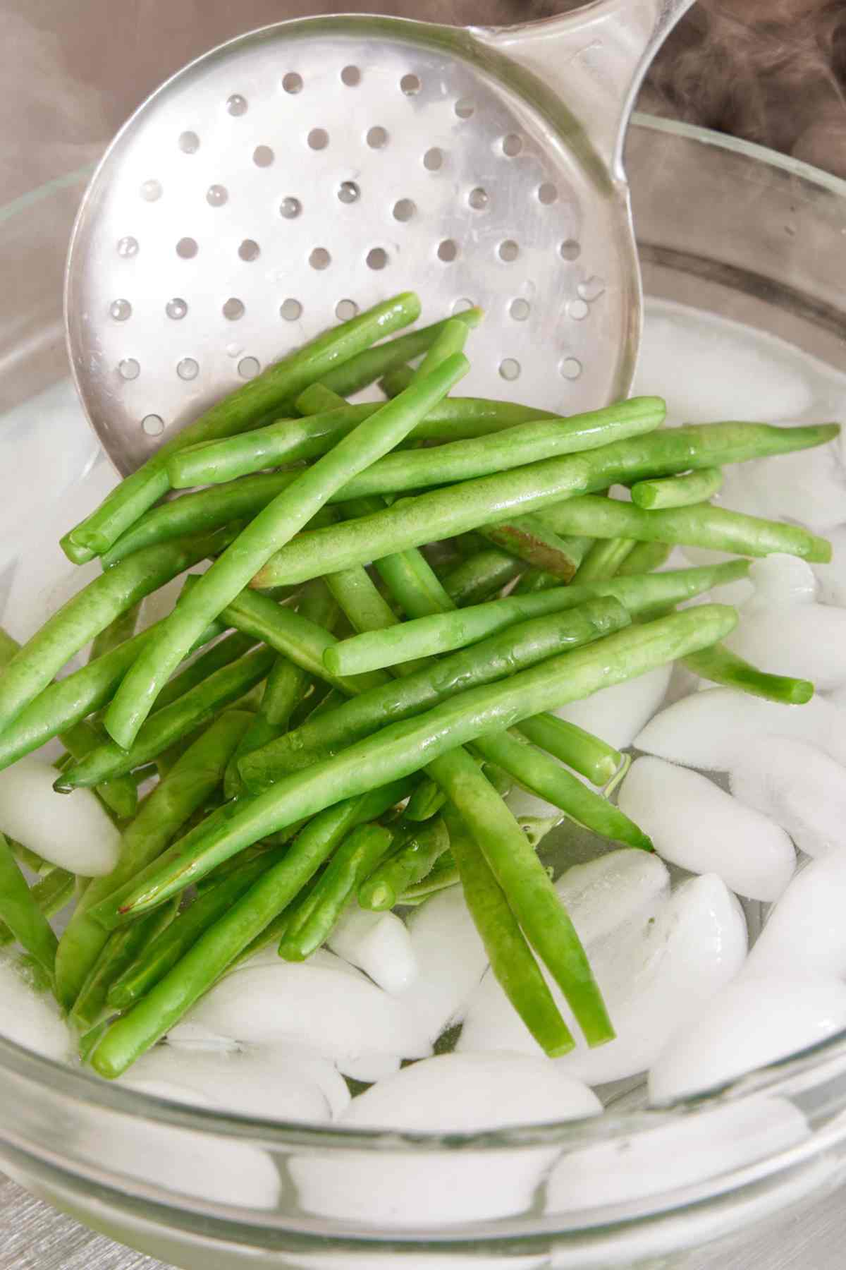 Green beans blanched and placed in an ice bath.