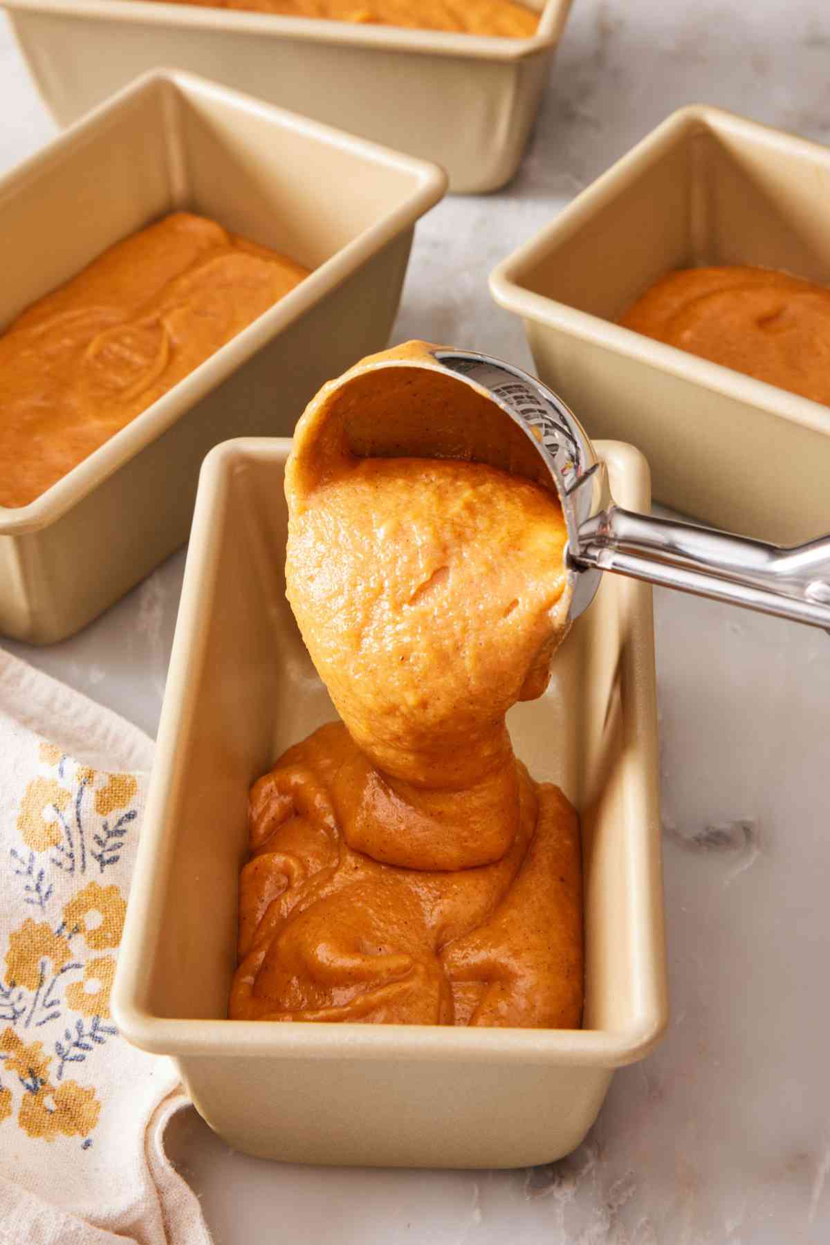 Pumpkin bread batter poured into mini loaf pans.