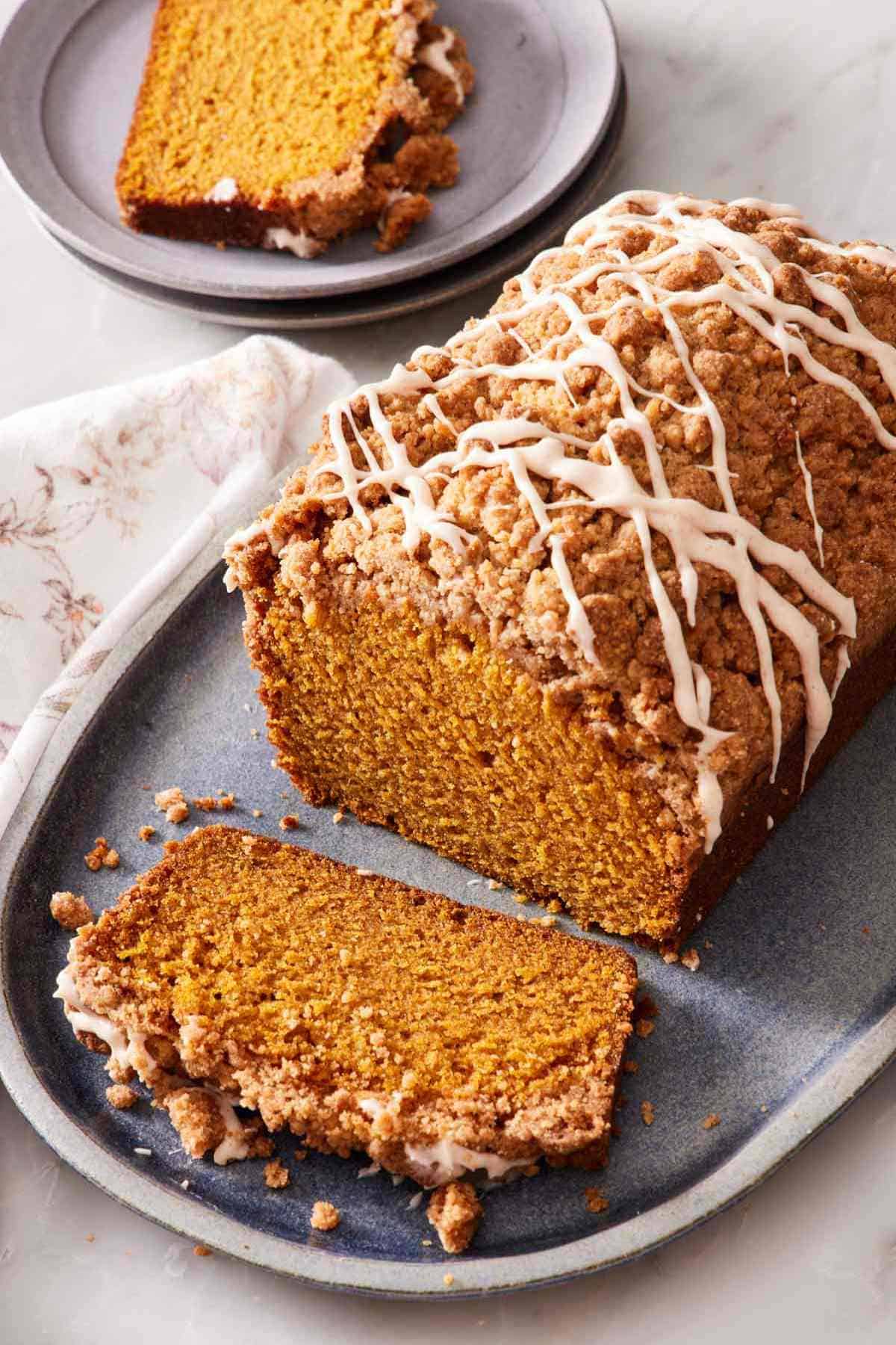 Pumpkin bread with a streusel topping and powdered sugar glaze.