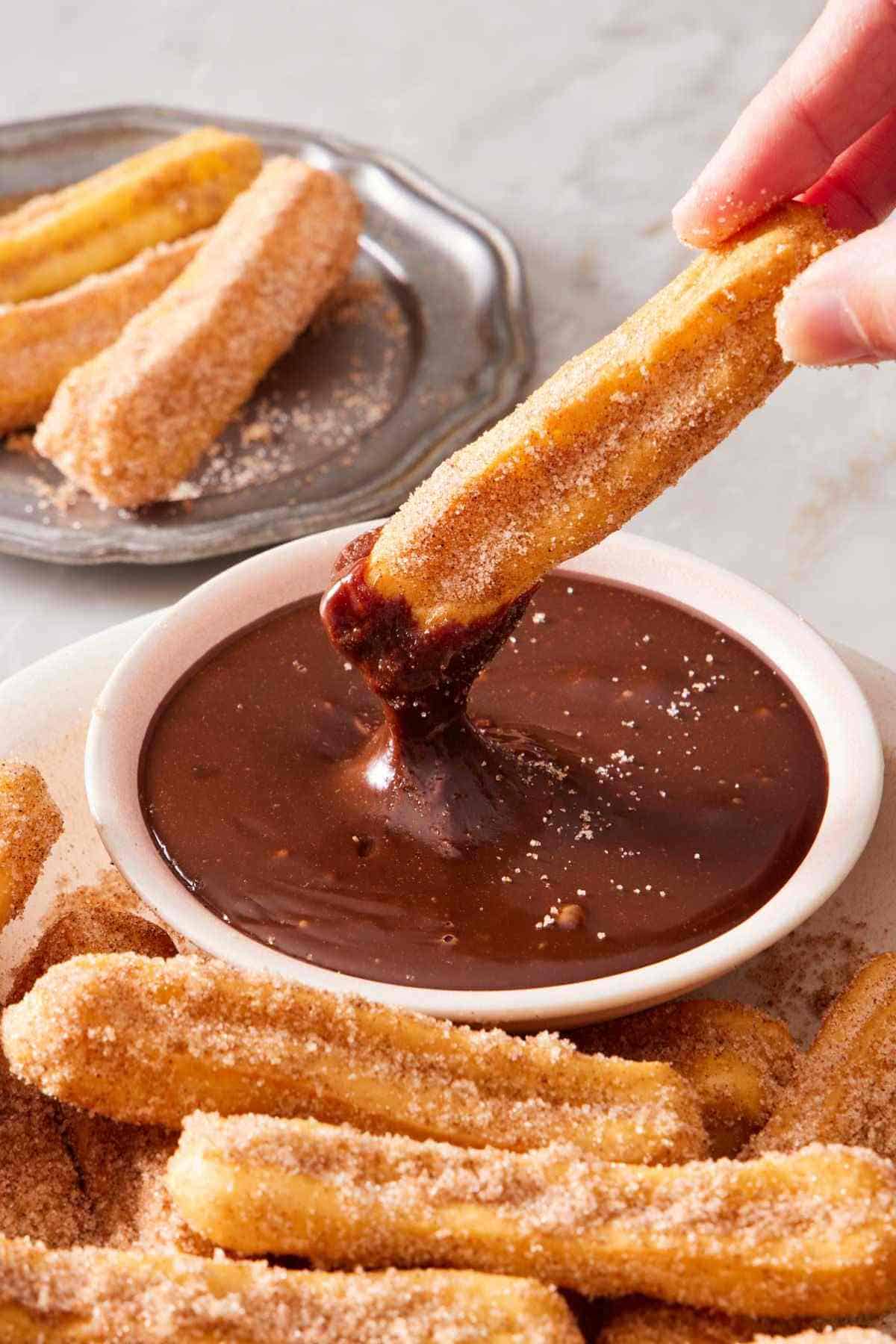 An air fryer churro dipped in chocolate sauce.