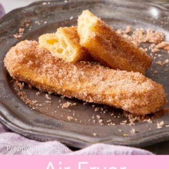 Pinterest graphic showing air fryer churros on a small plate, with one torn in two.