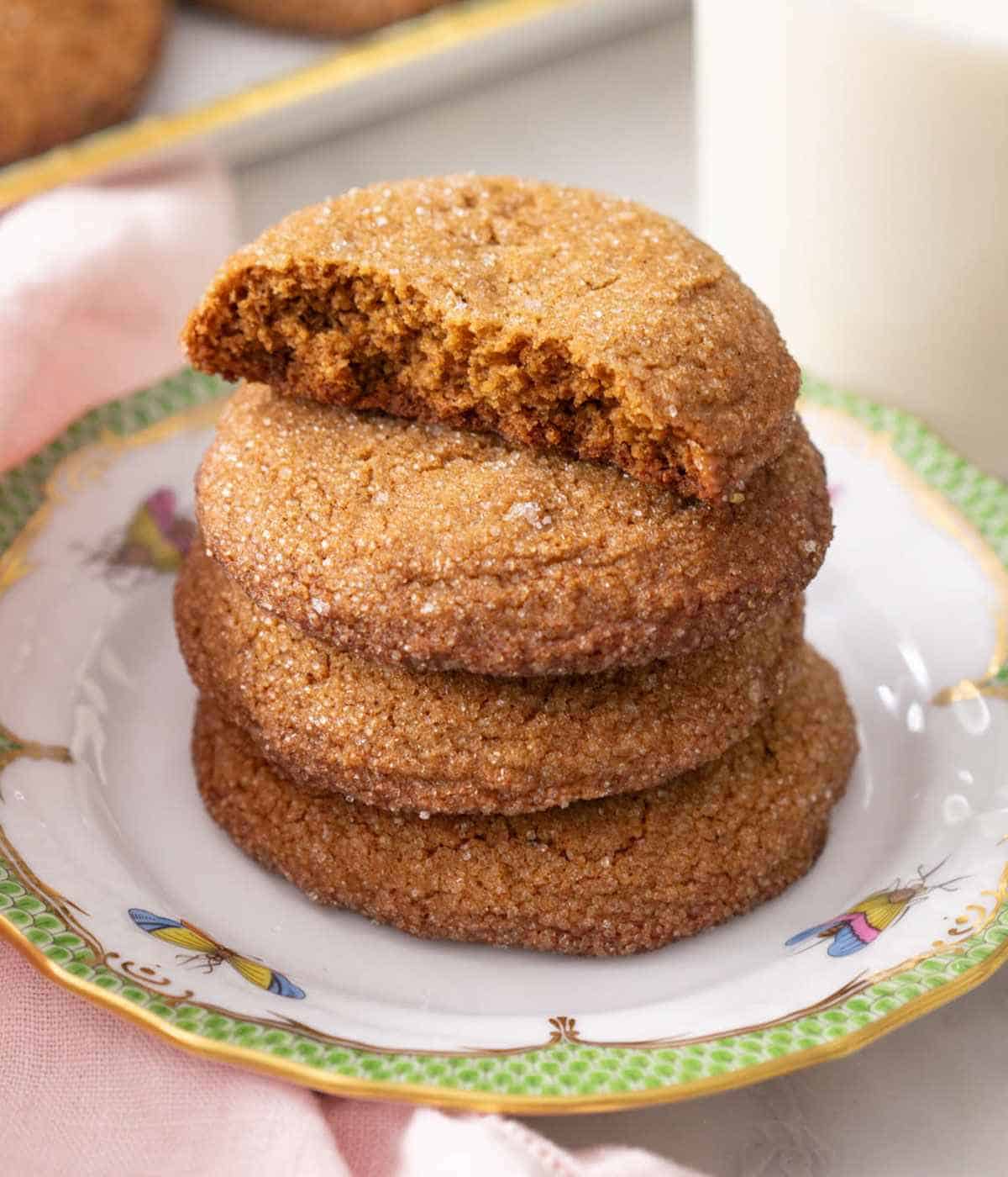 A stack of homemade gingersnaps. The one on top is half eaten.