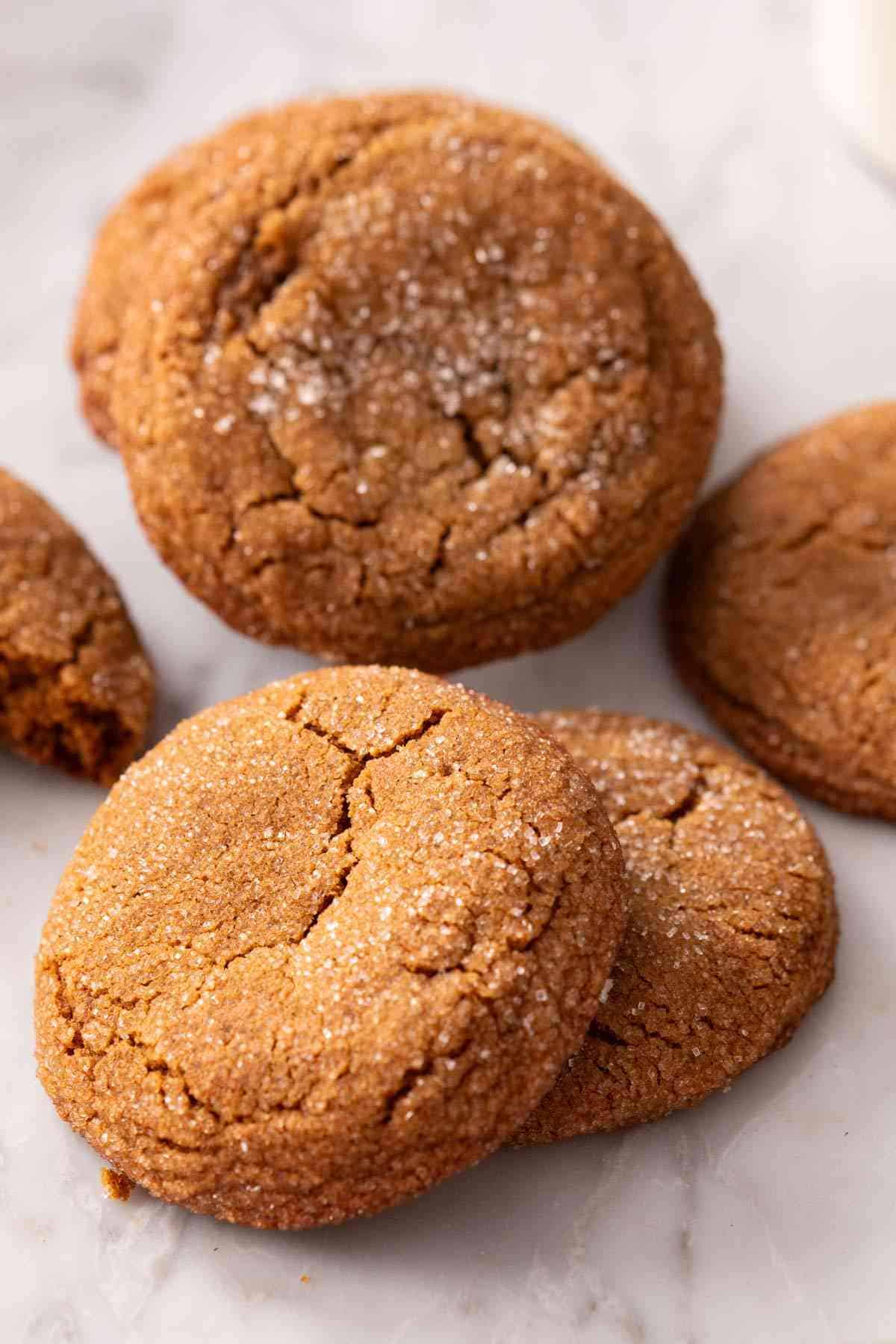 A few molasses cookies on a marble countertop.