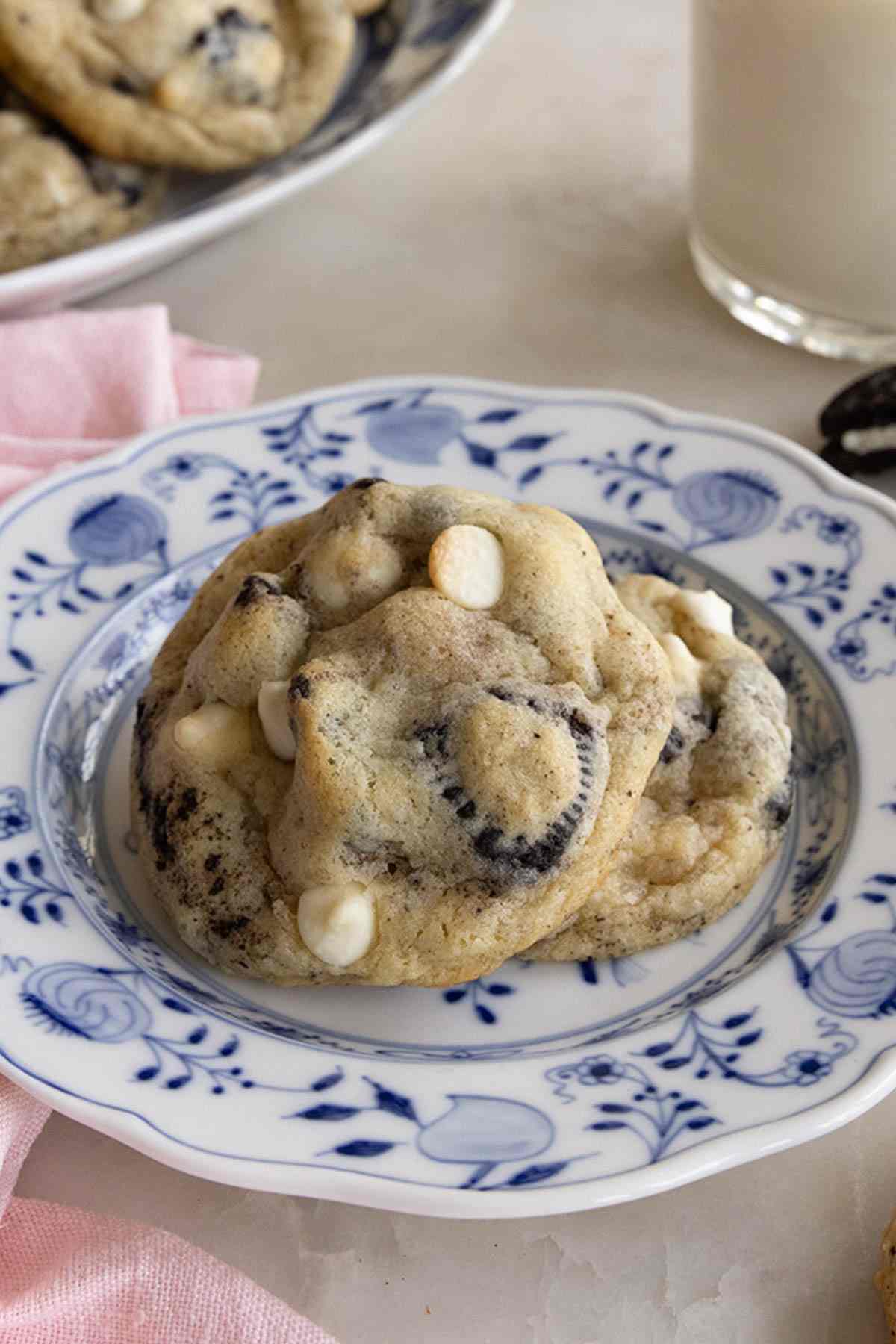 Two cookies and cream cookies on a patterned plate.