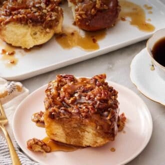 Pinterest graphic of a sticky bun on a plate with the rest of the buns in the background.