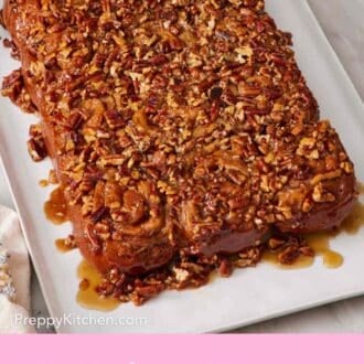 Pinterest graphic of a platter with sticky buns topped with pecan caramel sauce.