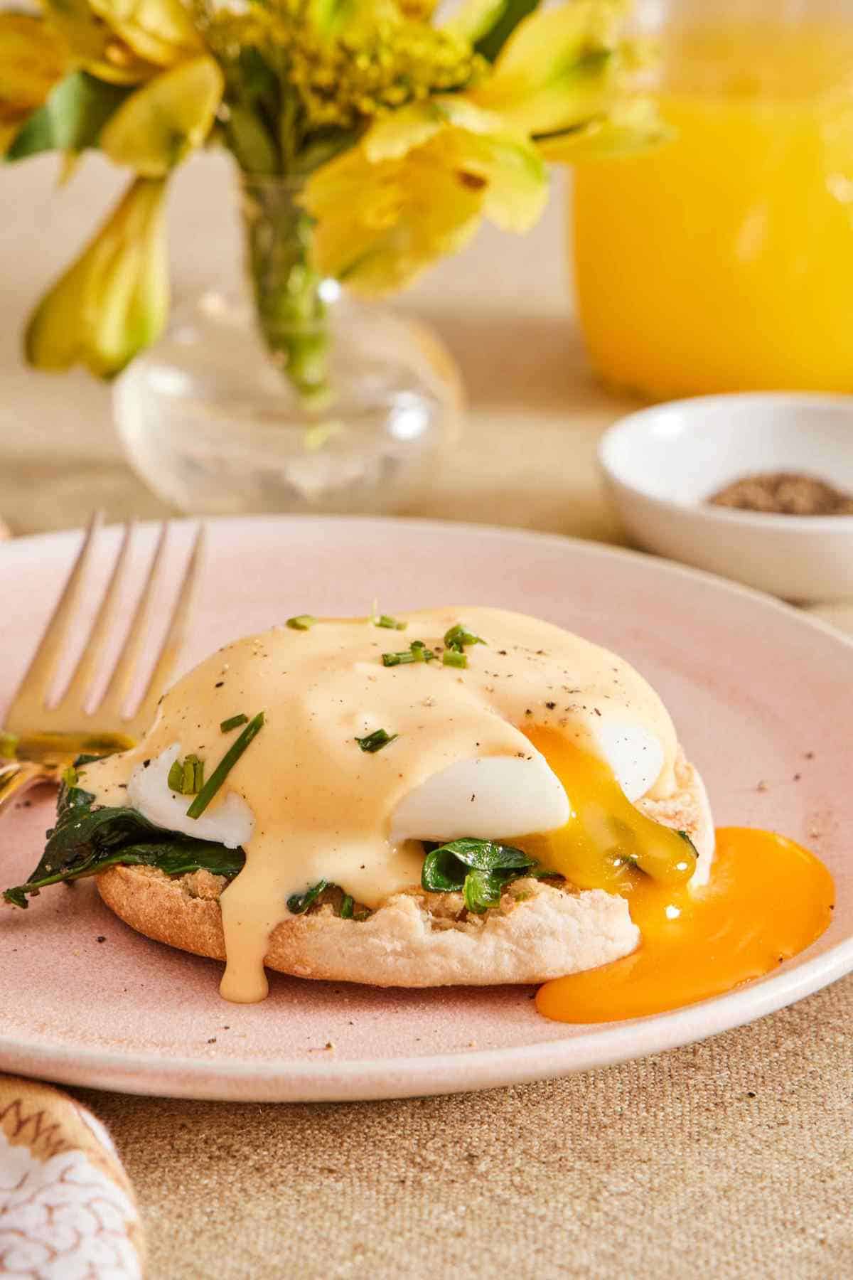 Eggs Florentine with the egg broken and yolk running off to the side.