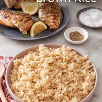Pinterest graphic of brown rice in a serving bowl with chicken in the background.