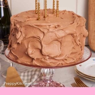 Pinterest graphic showing a yellow cake with frosting and candles on a cake stand.