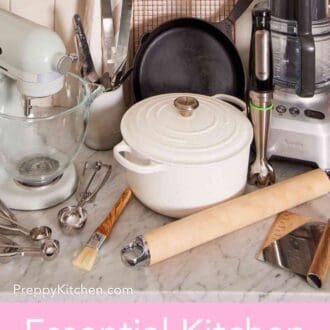 Pinterest graphic showing a stand mixer, immersion blender, Dutch oven, and more essential kitchen tools & essentials on a countertop.