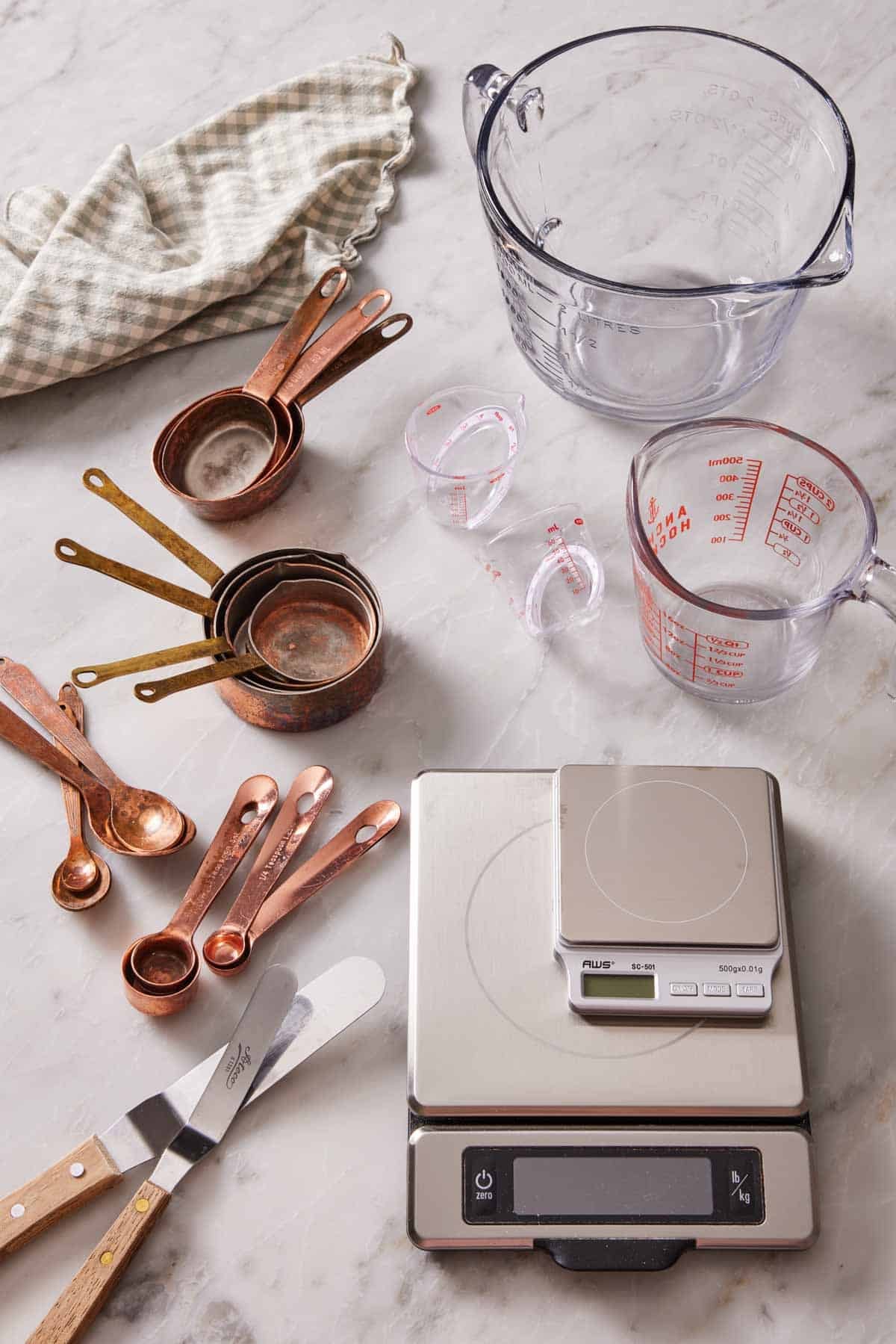Various essential baking tools on a marble countertop.