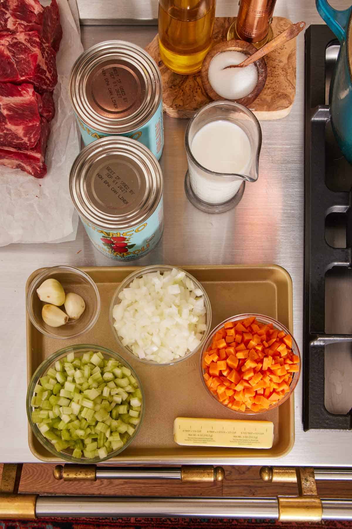 Overhead shot of mise in place, with chopped veggies, canned tomatoes, and other ingredients.
