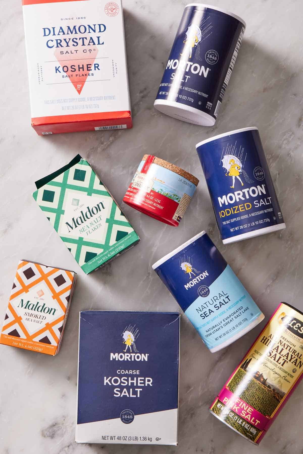 Overhead shot of different salt brands in their original packaging.