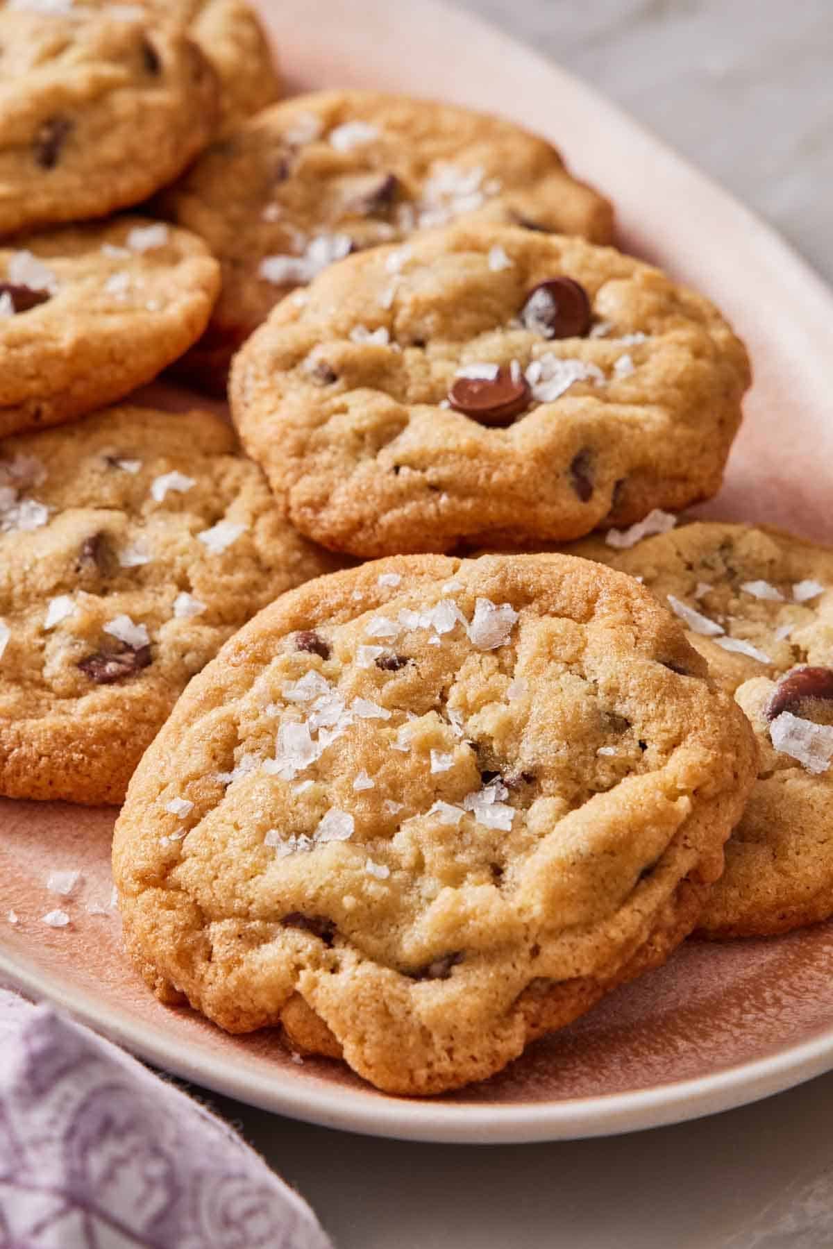 Choc chip cookies on a platter with flaky sea salt sprinkled on top.