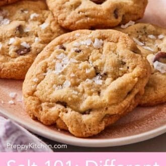 Pinterest graphic showing a close-up of choc chip cookies on a platter with flaky sea salt sprinkled on top.